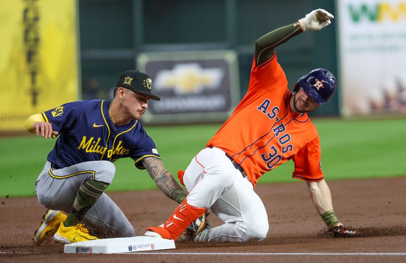 May 17, 2024; Houston, Texas, USA;  Houston Astros right fielder Kyle Tucker (30) is tagged out by Milwaukee Brewers second baseman Brice Turang (2) after he tried to stretch a double into a triple in the first inning at Minute Maid Park. Mandatory Credit: Thomas Shea-USA TODAY Sports