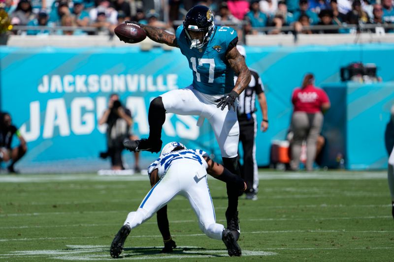 Jacksonville Jaguars tight end Evan Engram (17) leaps over Indianapolis Colts cornerback Kenny Moore II (23) after a catch during the first half of an NFL football game, Sunday, Oct. 15, 2023, in Jacksonville, Fla. (AP Photo/John Raoux)