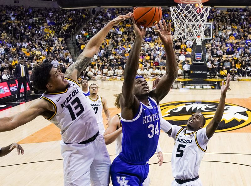 Dec 28, 2022; Columbia, Missouri, USA; Kentucky Wildcats forward Oscar Tshiebwe (34) shoots against Missouri Tigers forward Ronnie DeGray III (13) and guard D'Moi Hodge (5) during the second half at Mizzou Arena. Mandatory Credit: Jay Biggerstaff-USA TODAY Sports