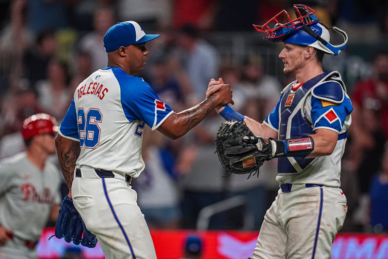 Jul 6, 2024; Cumberland, Georgia, USA; Atlanta Braves pitcher Raisel Iglesias (26) reacts with catcher Sean Murphy (12) after the Braves defeated the Philadelphia Phillies at Truist Park. Mandatory Credit: Dale Zanine-USA TODAY Sports