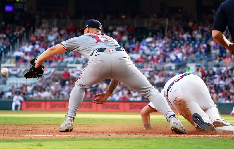 May 27, 2024; Cumberland, Georgia, USA; Atlanta Braves catcher Sean Murphy (12) slides into third base past Washington Nationals third baseman Nick Senzel (13) during the ninth inning at Truist Park. Mandatory Credit: John David Mercer-USA TODAY Sports