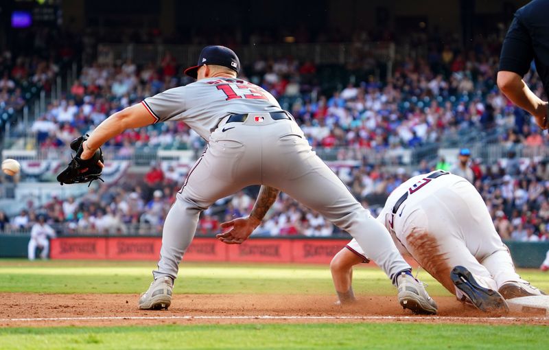 May 27, 2024; Cumberland, Georgia, USA; Atlanta Braves catcher Sean Murphy (12) slides into third base past Washington Nationals third baseman Nick Senzel (13) during the ninth inning at Truist Park. Mandatory Credit: John David Mercer-USA TODAY Sports