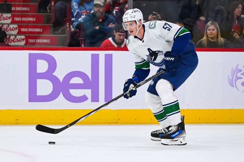 Nov 12, 2023; Montreal, Quebec, CAN; Vancouver Canucks defenseman Tyler Myers (57) plays the puck against the Montreal Canadiens during the first period at Bell Centre. Mandatory Credit: David Kirouac-USA TODAY Sports