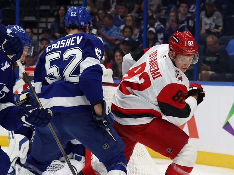 Sep 26, 2025; Tampa, Florida, USA; Carolina Hurricanes center Jesperi Kotkaniemi (82) skates with the puck as Tampa Bay Lightning defenseman Maxim Groshev (52) defends during the second period at Benchmark International Arena. Mandatory Credit: Kim Klement Neitzel-Imagn Images