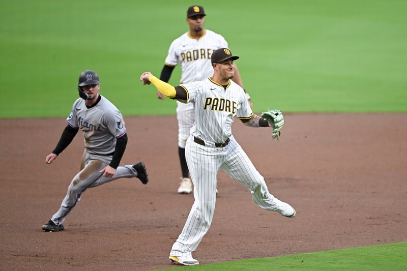 May 27, 2025; San Diego, California, USA; San Diego Padres third base Manny Machado (13) throws to home but can’t get the out on Miami Marlins outfielder Kyle Stowers (28) during the first inning at Petco Park. Mandatory Credit: Denis Poroy-Imagn Images