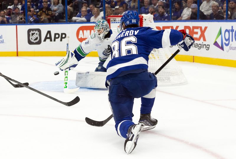 Oct 15, 2024; Tampa, Florida, USA; Tampa Bay Lightning right wing Nikita Kucherov (86) shoots on goal as Vancouver Canucks goaltender Arturs Silovs (31) makes a save during the first period at Amalie Arena. Mandatory Credit: Kim Klement Neitzel-Imagn Images