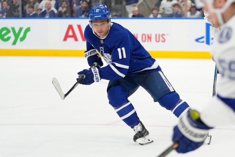 Oct 21, 2024; Toronto, Ontario, CAN; Toronto Maple Leafs forward Max Domi (11) defends against Tampa Bay Lightning forward Jake Guentzel (59) during the third period at Scotiabank Arena. Mandatory Credit: John E. Sokolowski-Imagn Images