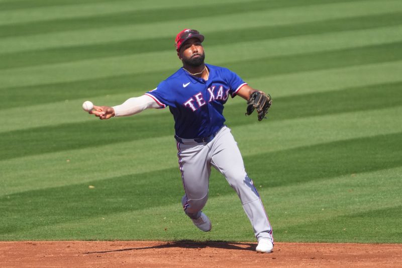 Mar 9, 2026; Peoria, Arizona, USA; Texas Rangers shortstop Ezequiel Duran (20) throws to first base against the San Diego Padres during the third inning at Peoria Sports Complex. Mandatory Credit: Joe Camporeale-Imagn Images