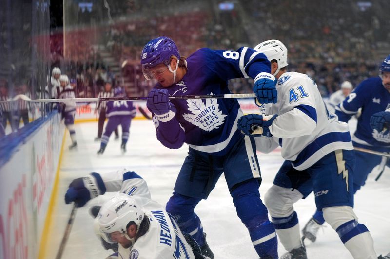 Oct 21, 2024; Toronto, Ontario, CAN;  Toronto Maple Leafs forward William Nylander (88) battles with Tampa Bay Lightning defenseman Victor Hedman (77) and forward Mitchell Chaffee (41) along the boards during the first period at Scotiabank Arena. Mandatory Credit: John E. Sokolowski-Imagn Images