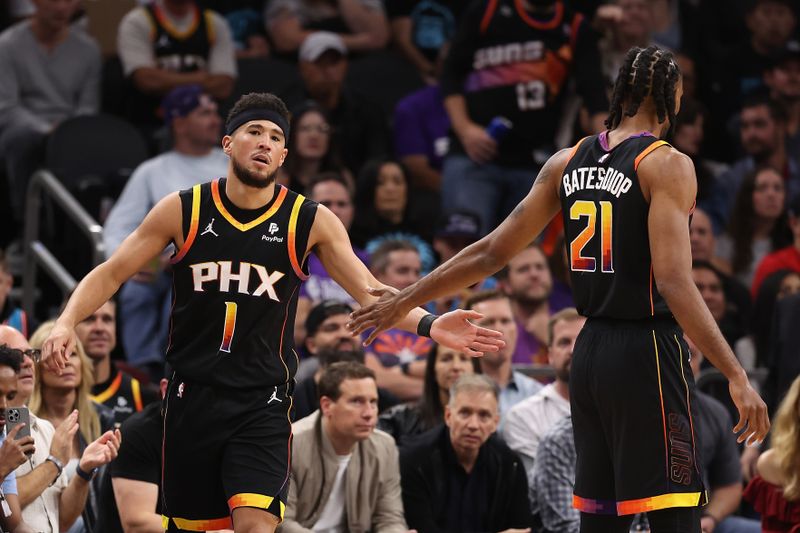 PHOENIX, ARIZONA - NOVEMBER 15: Devin Booker #1 of the Phoenix Suns high fives Keita Bates-Diop #21 after scoring against the Minnesota Timberwolves during the first half of the NBA game at Footprint Center on November 15, 2023 in Phoenix, Arizona. The Suns defeated the Timberwolves 133-115.  NOTE TO USER: User expressly acknowledges and agrees that, by downloading and or using this photograph, User is consenting to the terms and conditions of the Getty Images License Agreement.  (Photo by Christian Petersen/Getty Images)