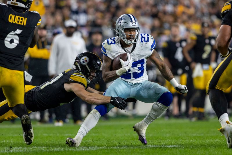 Dallas Cowboys running back Rico Dowdle (23) rushes in front of Pittsburgh Steelers linebacker Payton Wilson (41) during an NFL football game, Sunday, Oct. 6, 2024, in Pittsburgh. (AP Photo/Matt Durisko)