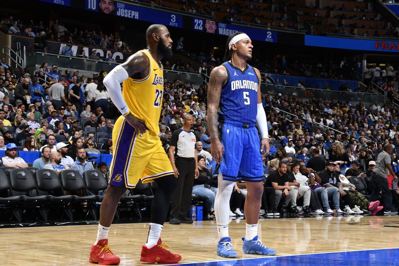 ORLANDO, FL - MARCH 24:   LeBron James #23 and Paolo Banchero #5 of the Orlando Magic look on during the game between the Los Angeles Lakers and the Orlando Magic  on March 24, 2025 at Kia Center in Orlando, Florida. NOTE TO USER: User expressly acknowledges and agrees that, by downloading and or using this photograph, User is consenting to the terms and conditions of the Getty Images License Agreement. Mandatory Copyright Notice: Copyright 2025 NBAE (Photo by Gary Bassing/NBAE via Getty Images)