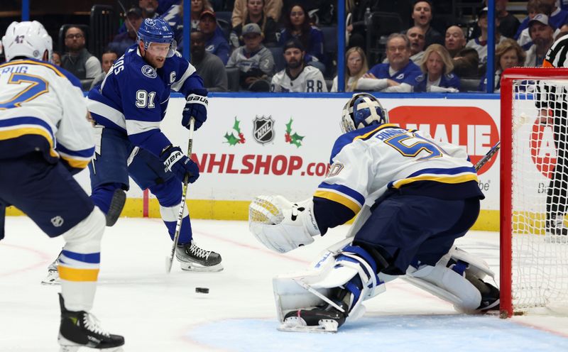 Dec 19, 2023; Tampa, Florida, USA; Tampa Bay Lightning center Steven Stamkos (91) shoots as St. Louis Blues goaltender Jordan Binnington (50) defends during the first period at Amalie Arena. Mandatory Credit: Kim Klement Neitzel-USA TODAY Sports