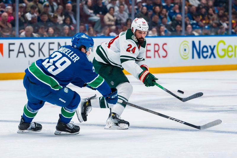 Apr 12, 2025; Vancouver, British Columbia, CAN; Minnesota Wild defenseman Zach Bogosian (24) passes around Vancouver Canucks forward Ty Mueller (39) in the first period at Rogers Arena. Mandatory Credit: Bob Frid-Imagn Images