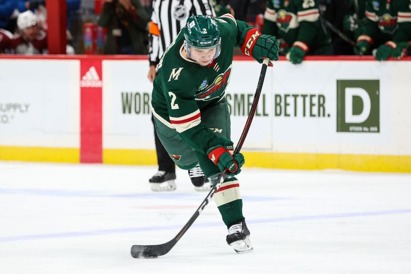 Oct 17, 2022; Saint Paul, Minnesota, USA; Minnesota Wild defenseman Calen Addison (2) shoots the puck during the second period against the Colorado Avalanche at Xcel Energy Center. Mandatory Credit: Matt Krohn-USA TODAY Sports