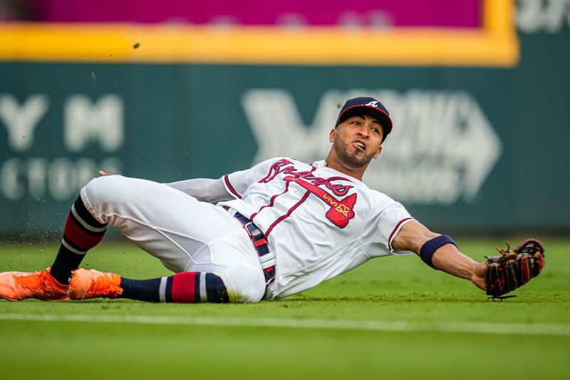 Aug 22, 2023; Cumberland, Georgia, USA; Atlanta Braves left fielder Eddie Rosario (8) makes a sliding catch on a ball hit by New York Mets shortstop Francisco Lindor (12) (not shown) during the first inning at Truist Park. Mandatory Credit: Dale Zanine-USA TODAY Sports