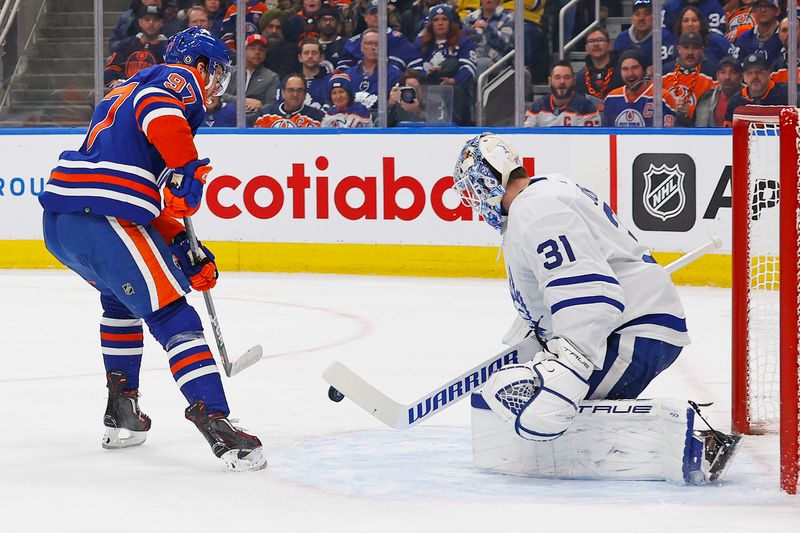 Jan 16, 2024; Edmonton, Alberta, CAN; Toronto Maple Leafs goaltender Martin Jones (31) makes a save on one Edmonton Oilers forward Connor McDavid (97) during the first period at Rogers Place. Mandatory Credit: Perry Nelson-USA TODAY Sports