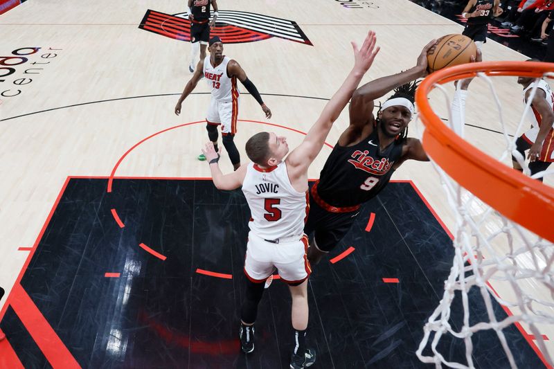 PORTLAND, OREGON - FEBRUARY 27: Jerami Grant #9 of the Portland Trail Blazers is fouled while shooting by Nikola Jovic #5 of the Miami Heat during the first half at Moda Center on February 27, 2024 in Portland, Oregon. NOTE TO USER: User expressly acknowledges and agrees that, by downloading and or using this photograph, User is consenting to the terms and conditions of the Getty Images License Agreement. (Photo by Soobum Im/Getty Images)