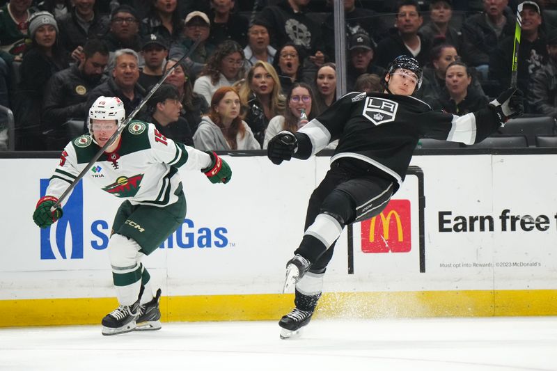 Apr 15, 2024; Los Angeles, California, USA; Minnesota Wild center Mason Shaw (15) is penalized for holding against LA Kings defenseman Jordan Spence (21) in the third period at Crypto.com Arena. Mandatory Credit: Kirby Lee-USA TODAY Sports