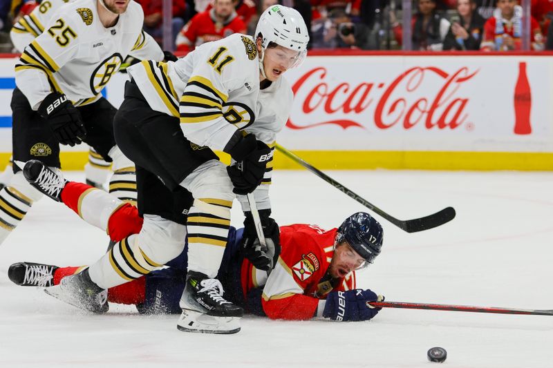 May 8, 2024; Sunrise, Florida, USA; Florida Panthers center Evan Rodrigues (17) dives for the puck against Boston Bruins center Trent Frederic (11) during the first period in game two of the second round of the 2024 Stanley Cup Playoffs at Amerant Bank Arena. Mandatory Credit: Sam Navarro-USA TODAY Sports