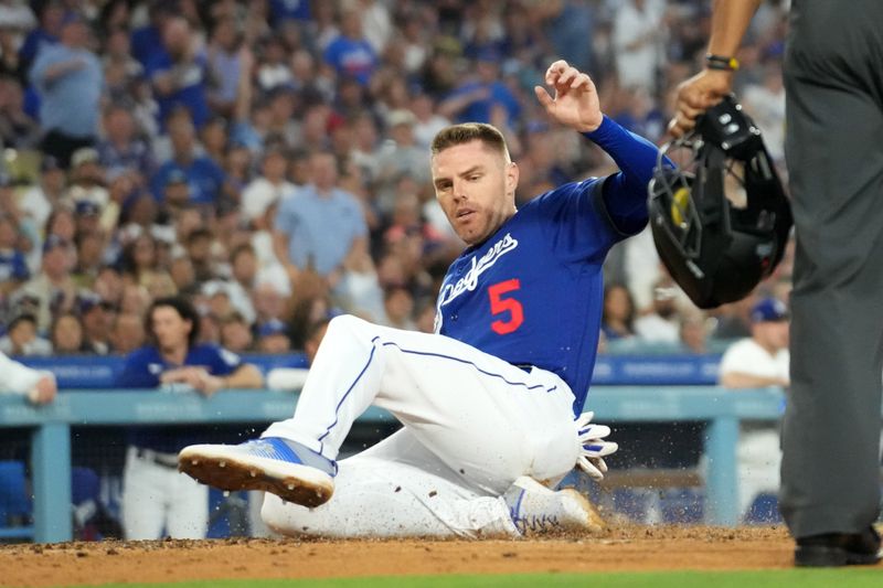 Jul 25, 2023; Los Angeles, California, USA; Los Angeles Dodgers first baseman Freddie Freeman (5) slides into home plate to score in the third inning against the Toronto Blue Jays at Dodger Stadium. Mandatory Credit: Kirby Lee-USA TODAY Sports