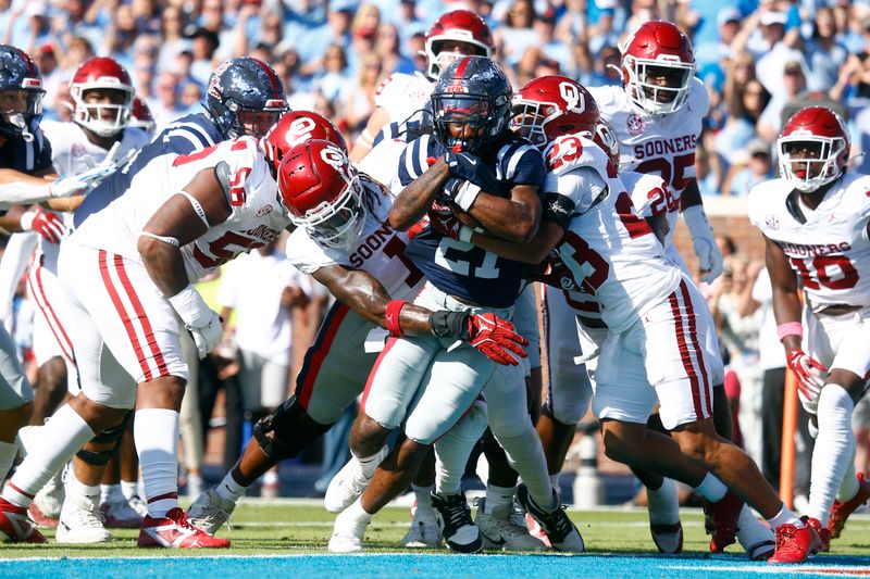 Oct 26, 2024; Oxford, Mississippi, USA; Mississippi Rebels running back Henry Parrish Jr. (21) runs the ball for a touchdown as Oklahoma Sooners linebacker Dasan McCullough (1) and defensive back Eli Bowen (23) attempt to make the tackle during the first half at Vaught-Hemingway Stadium. Mandatory Credit: Petre Thomas-Imagn Images