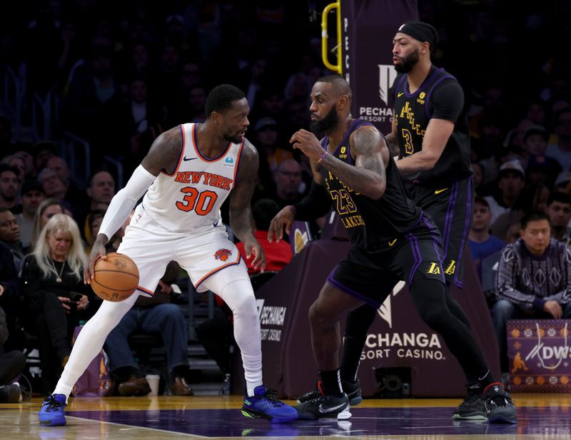 LOS ANGELES, CALIFORNIA - DECEMBER 18: Julius Randle #30 of the New York Knicks faces a double team from LeBron James #23 and Anthony Davis #3 of the Los Angeles Lakers during a 114-109 Knicks win at Crypto.com Arena on December 18, 2023 in Los Angeles, California. NOTE TO USER: User expressly acknowledges and agrees that, by downloading and or using this photograph, User is consenting to the terms and conditions of the Getty Images License Agreement. (Photo by Harry How/Getty Images)