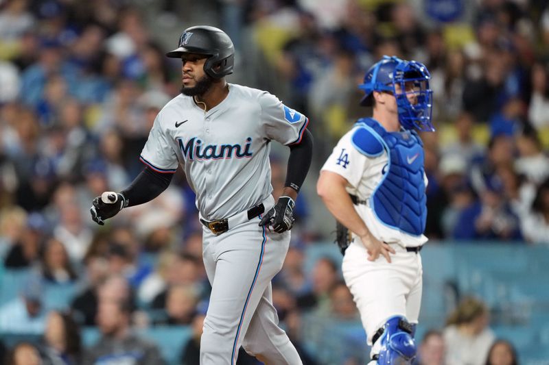 May 7, 2024; Los Angeles, California, USA; Miami Marlins designated hitter Bryan De La Cruz (14) reacts after hitting a home run in the sixth inning as Los Angeles Dodgers catcher Will Smith (16) watches at Dodger Stadium. Mandatory Credit: Kirby Lee-USA TODAY Sports