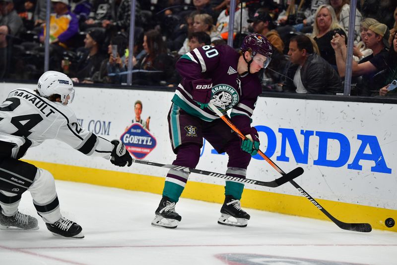 Nov 24, 2023; Anaheim, California, USA; Anaheim Ducks defenseman Jackson LaCombe (60) moves the puck against Los Angeles Kings center Phillip Danault (24) during the third period at Honda Center. Mandatory Credit: Gary A. Vasquez-USA TODAY Sports