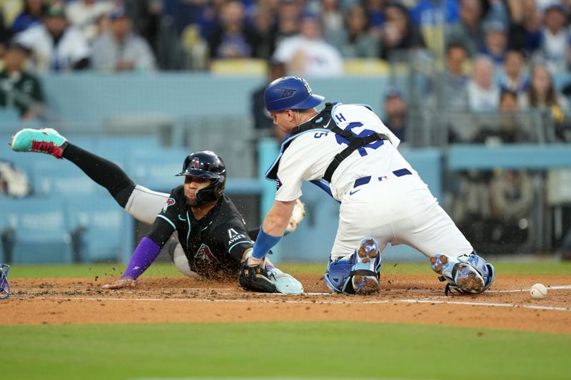 May 21, 2024; Los Angeles, California, USA; Arizona Diamondbacks left fielder Lourdes Gurriel Jr. (12) slides into second base to beat a throw to Los Angeles Dodgers catcher Will Smith (16) to score in the second inning at Dodger Stadium. Mandatory Credit: Kirby Lee-USA TODAY Sports