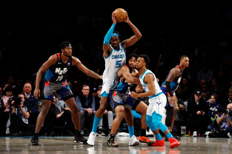 NEW YORK, NEW YORK - NOVEMBER 30: Mark Williams #5 of the Charlotte Hornets looks to pass as Day'Ron Sharpe #20 and Cam Thomas #24 of the Brooklyn Nets defend during the second half at Barclays Center on November 30, 2023 in the Brooklyn borough of New York City. The Hornets won 129-128. NOTE TO USER: User expressly acknowledges and agrees that, by downloading and/or using this Photograph, user is consenting to the terms and conditions of the Getty Images License Agreement. (Photo by Sarah Stier/Getty Images)