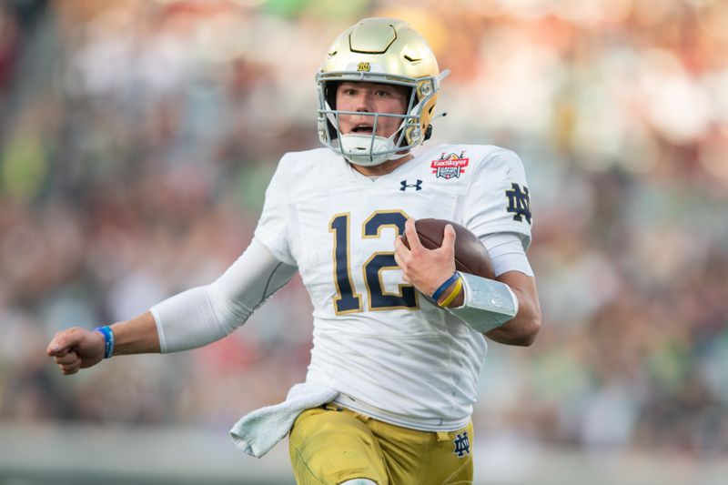 Dec 30, 2022; Jacksonville, FL, USA; Notre Dame Fighting Irish quarterback Tyler Buchner (12) runs for a touchdown against the South Carolina Gamecocks in the second quarter in the 2022 Gator Bowl at TIAA Bank Field. Mandatory Credit: Jeremy Reper-USA TODAY Sports