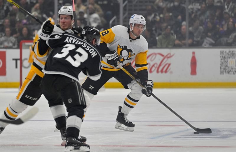 Feb 11, 2023; Los Angeles, California, USA;  ittsburgh Penguins defenseman Brian Dumoulin (8) skates the puck down ice as left wing Brock McGinn (23) blocks Los Angeles Kings right wing Viktor Arvidsson (33) in the first period at Crypto.com Arena. Mandatory Credit: Jayne Kamin-Oncea-USA TODAY Sports