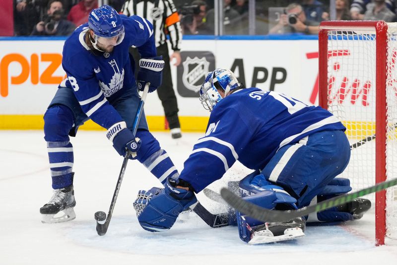 Oct 21, 2024; Toronto, Ontario, CAN; Toronto Maple Leafs defenceman Chris Tanev (8) and goaltender Anthony Stolarz (41) cover up a rebound against the Tampa Bay Lightning  during the second period at Scotiabank Arena. Mandatory Credit: John E. Sokolowski-Imagn Images