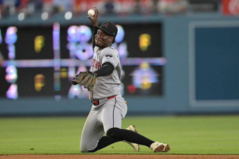 May 21, 2025; Los Angeles, California, USA; Arizona Diamondbacks shortstop Geraldo Perdomo (2) makes a stop on a ball hit by Los Angeles Dodgers second baseman Miguel Rojas (72) but has not play in the sixth inning at Dodger Stadium. Mandatory Credit: Jayne Kamin-Oncea-Imagn Images