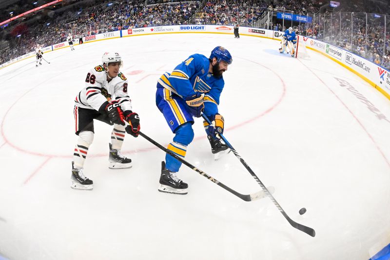 Mar 22, 2025; St. Louis, Missouri, USA;  St. Louis Blues defenseman Nick Leddy (4) and Chicago Blackhawks center Teuvo Teravainen (86) battle for the puck during the third period at Enterprise Center. Mandatory Credit: Jeff Curry-Imagn Images