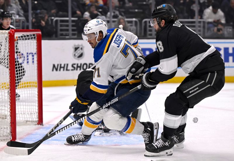 Mar 5, 2025; Los Angeles, California, USA;  St. Louis Blues right wing Mathieu Joseph (71) shot gets deflected by Los Angeles Kings goaltender Darcy Kuemper (35) with defenseman Drew Doughty (8) defending during the third period at Crypto.com Arena. Mandatory Credit: Alex Gallardo-Imagn Images