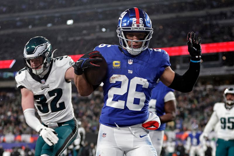 New York Giants running back Saquon Barkley (26) rushes for a touchdown past Philadelphia Eagles safety Reed Blankenship (32) during an NFL football game Sunday, Jan. 7, 2024, in East Rutherford, N.J. (AP Photo/Adam Hunger)