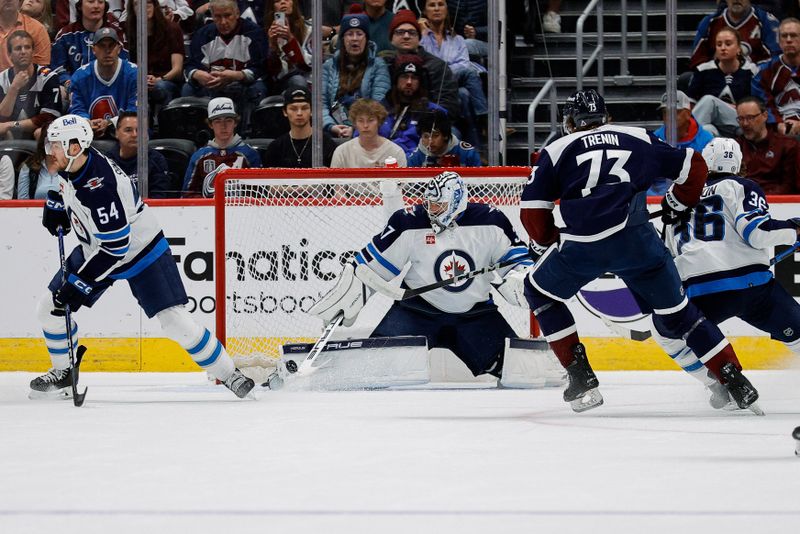 Apr 13, 2024; Denver, Colorado, USA; Winnipeg Jets goaltender Connor Hellebuyck (37) makes a save against Colorado Avalanche center Yakov Trenin (73) as center Morgan Barron (36) and defenseman Dylan Samberg (54) defend in the first period at Ball Arena. Mandatory Credit: Isaiah J. Downing-USA TODAY Sports