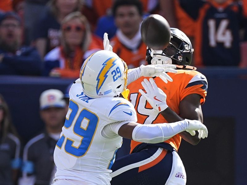 Los Angeles Chargers cornerback Tarheeb Still (29) breaks up a pass intended for Denver Broncos wide receiver Marvin Mims Jr. (19) during the first half of an NFL football game, Sunday, Oct. 13, 2024, in Denver. (AP Photo/David Zalubowski)