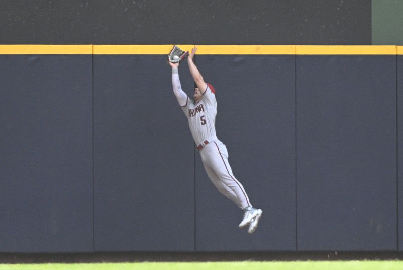 Jun 21, 2023; Milwaukee, Wisconsin, USA; Arizona Diamondbacks center fielder Alek Thomas (5) makes a catch at the outfield wall against the Milwaukee Brewers in the fifth inning at American Family Field. Mandatory Credit: Michael McLoone-USA TODAY Sports