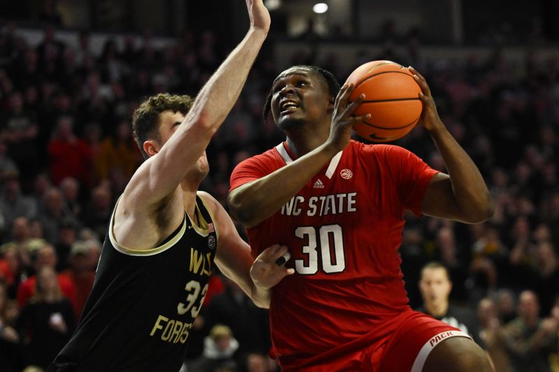 Jan 28, 2023; Winston-Salem, North Carolina, USA;   North Carolina State Wolfpack forward D.J. Burns Jr. (30) shoots over Wake Forest Demon Deacons forward Matthew Marsh (33) during the second half at Lawrence Joel Veterans Memorial Coliseum. Mandatory Credit: William Howard-USA TODAY Sports