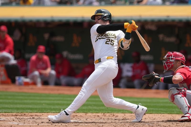 Jul 21, 2024; Oakland, California, USA; Oakland Athletics designated hitter Brent Rooker (25) hits an RBI double against the Los Angeles Angels during the third inning at Oakland-Alameda County Coliseum. Mandatory Credit: Darren Yamashita-USA TODAY Sports