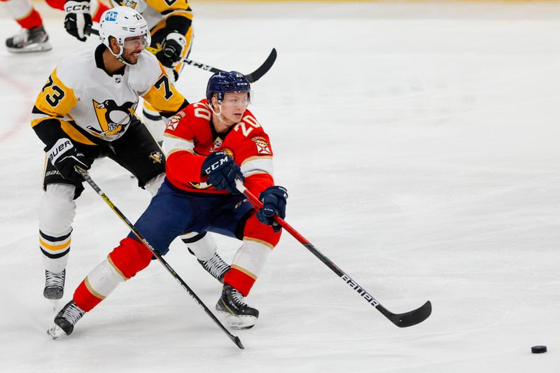 Dec 15, 2022; Sunrise, Florida, USA; Florida Panthers center Aleksi Heponiemi (20) moves the puck ahead of Pittsburgh Penguins defenseman Pierre-Olivier Joseph (73) during the third period at FLA Live Arena. Mandatory Credit: Sam Navarro-USA TODAY Sports