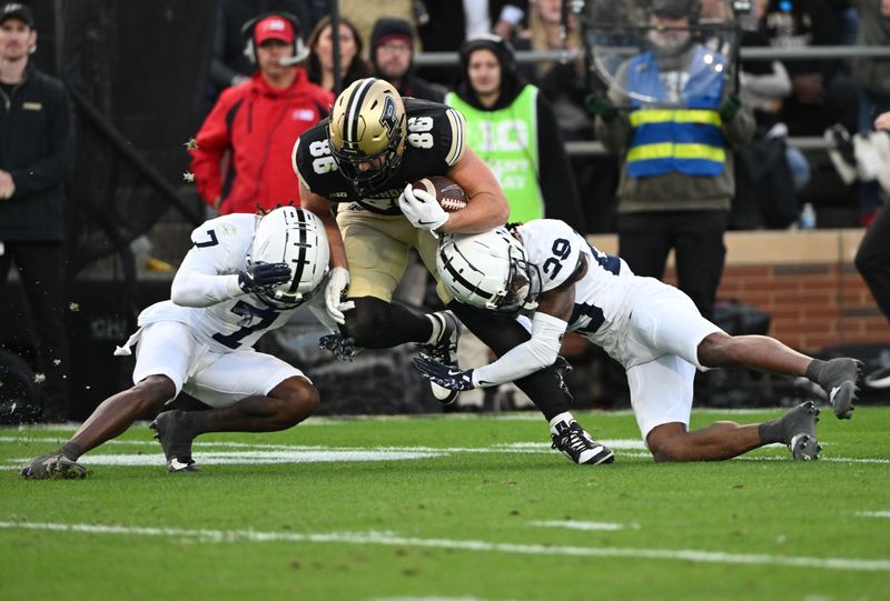 Nov 16, 2024; West Lafayette, Indiana, USA; Purdue Boilermakers tight end Max Klare (86) is tackled by Penn State Nittany Lions cornerback Audavion Collins (29) and cornerback Zion Tracy (7) during the second quarter at Ross-Ade Stadium. Mandatory Credit: Marc Lebryk-Imagn Images