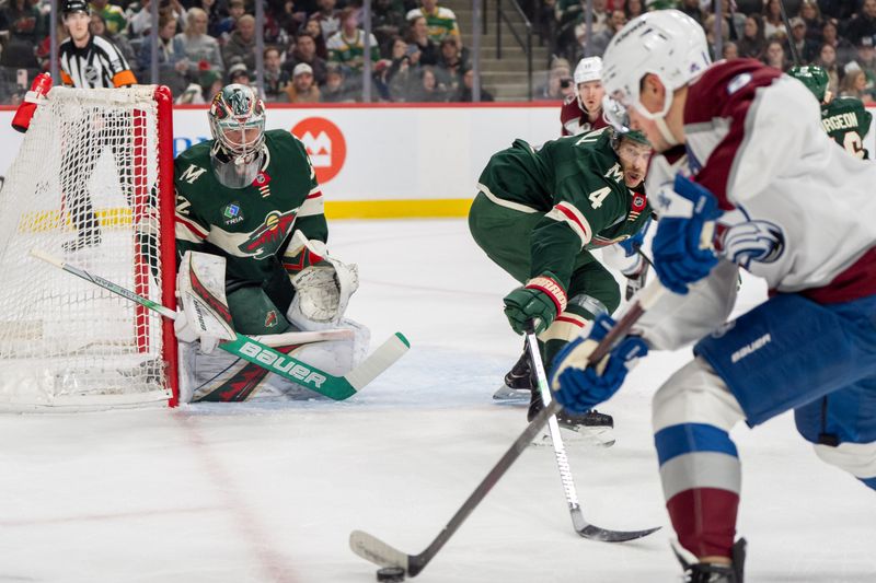 Mar 11, 2025; Saint Paul, Minnesota, USA; Minnesota Wild goaltender Filip Gustavsson (32) and defenseman Jon Merrill (4) defend against the charging. Colorado Avalanche defenseman Cale Makar (8) in the first period at Xcel Energy Center. Mandatory Credit: Matt Blewett-Imagn Images