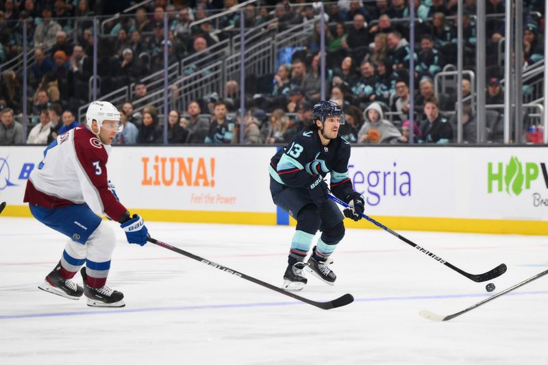 Nov 13, 2023; Seattle, Washington, USA; Seattle Kraken left wing Brandon Tanev (13) advances the puck while Colorado Avalanche defenseman Jack Johnson (3) chases during the second period at Climate Pledge Arena. Mandatory Credit: Steven Bisig-USA TODAY Sports