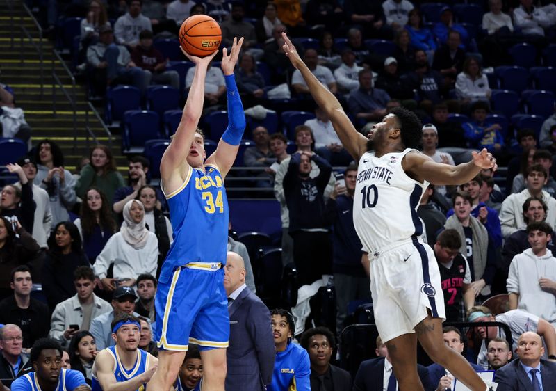 Jan 14, 2026; University Park, Pennsylvania, USA; UCLA Bruins forward Tyler Bilodeau (34) attempts a three-point shot as Penn State Nittany Lions forward Josh Reed (10) defends during the second half at Bryce Jordan Center. Mandatory Credit: Matthew O'Haren-Imagn Images