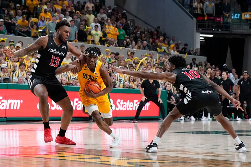 Jan 13, 2024; Waco, Texas, USA; Baylor Bears guard Ja'Kobe Walter (4) drives between Cincinnati Bearcats forward Jamille Reynolds (13) and guard Josh Reed (10) during the second half at Paul and Alejandra Foster Pavilion. Mandatory Credit: Raymond Carlin III-USA TODAY Sports