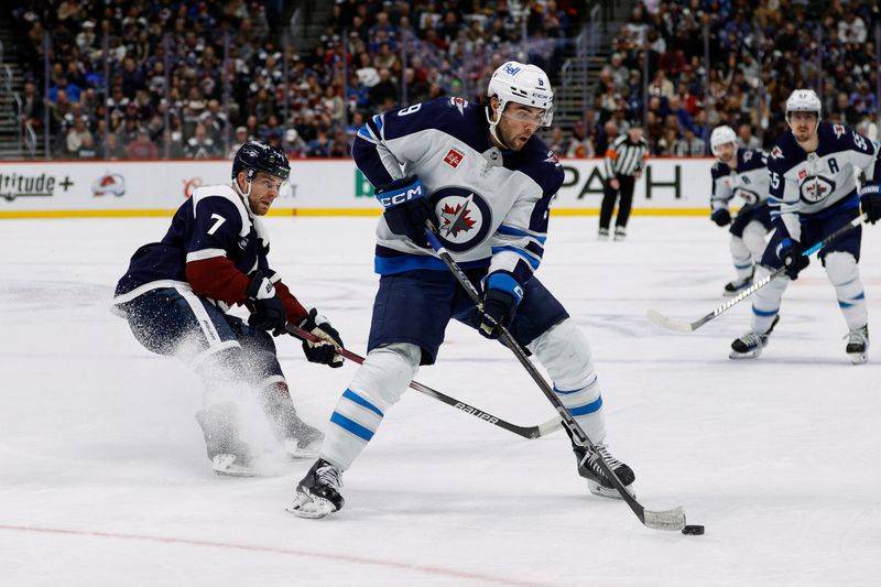 Jan 22, 2025; Denver, Colorado, USA; Winnipeg Jets left wing Alex Iafallo (9) controls the puck against Colorado Avalanche defenseman Devon Toews (7) in the first period at Ball Arena. Mandatory Credit: Isaiah J. Downing-Imagn Images